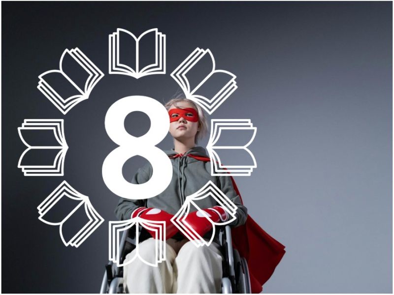 En pige i en kørestol med rød superhelt kappe på samt boksehandsker